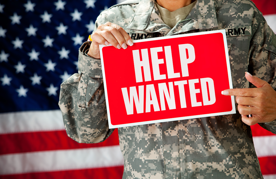 veteran holding help wanted sign